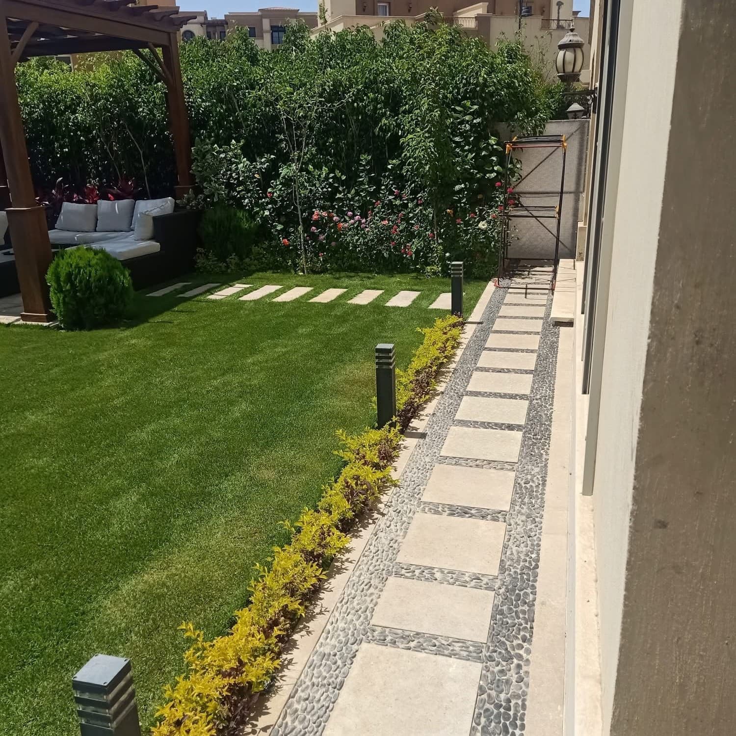 حديقة سكنية بممر حجري وتوزيع نباتي